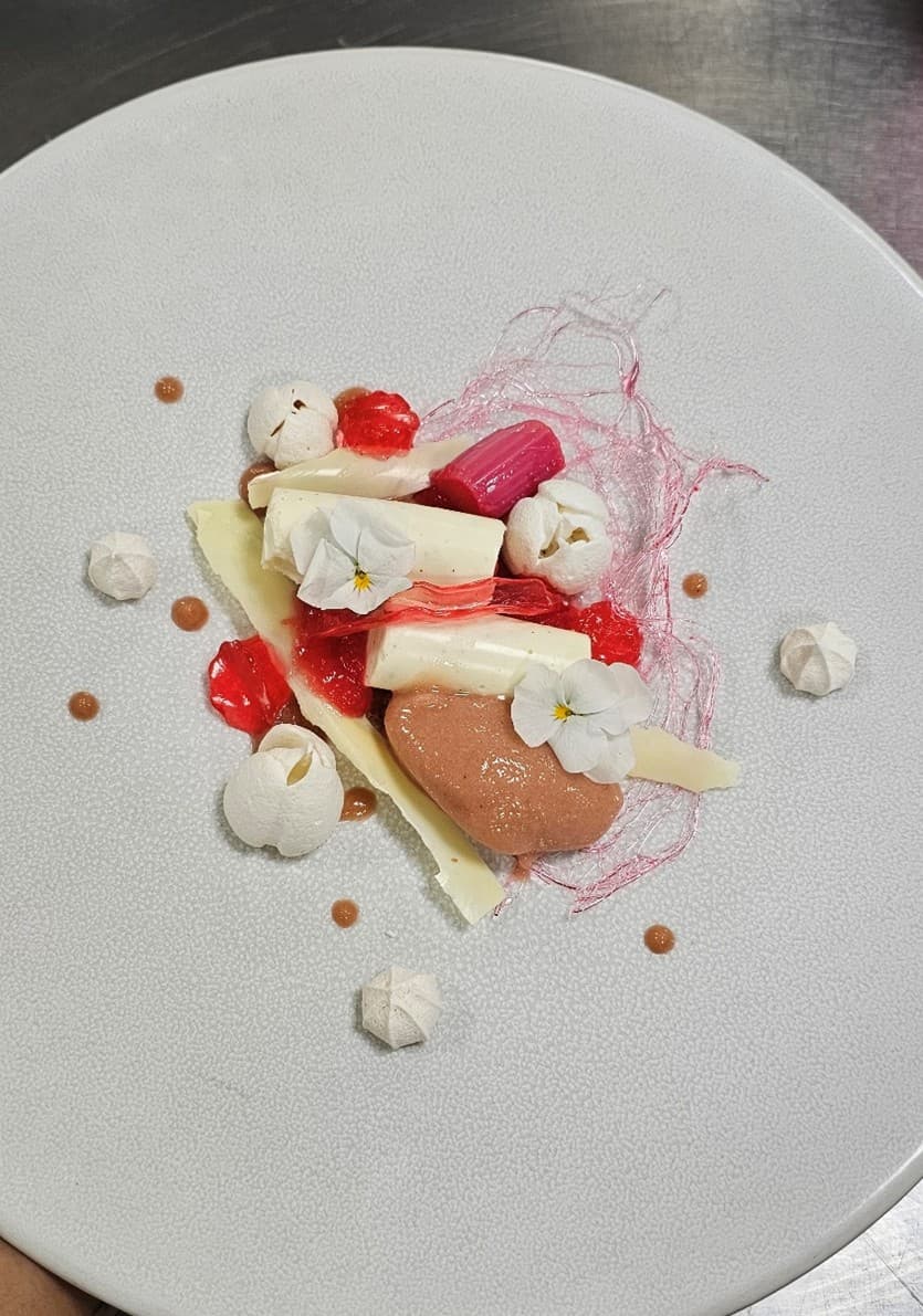 Vanilla and rhubarb cheesecake with white chocolate shards, sugar work, rhubarb sorbet, pickled rhubarb, rhubarb and lemon gel and French vanilla meringue.